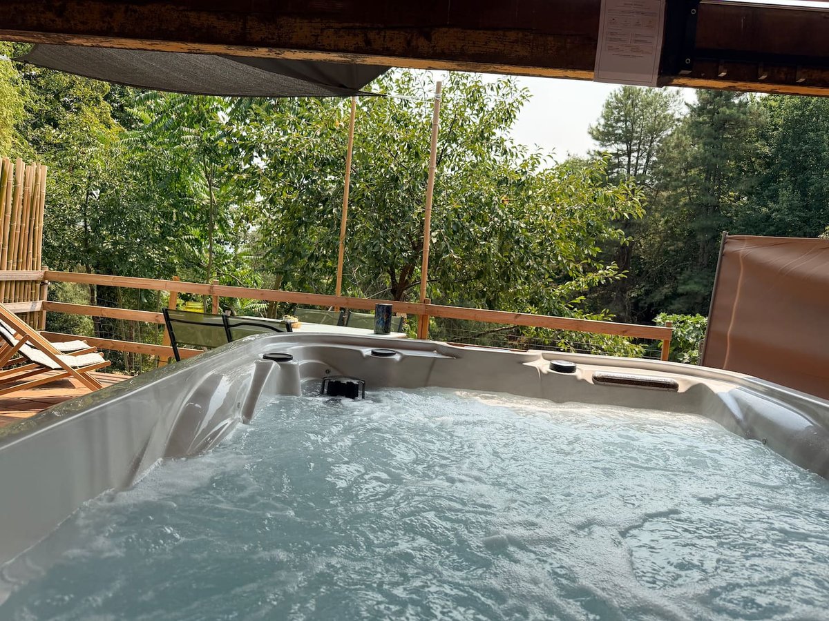 Jacuzzi privatif de Lou Pitchoun sous sa pergola, face aux bois du domaine